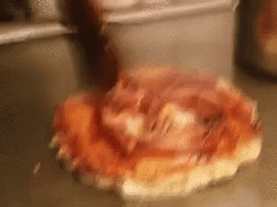 A Pizza With Ham And Cheese Is Sitting On A Counter . GIF