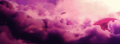 A Plane Flying Through A Cloudy Sky With A Red Object In The Background GIF
