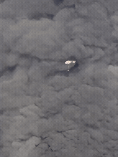 A Plane Is Flying Through A Cloudy Sky With A White Object In The Foreground GIF