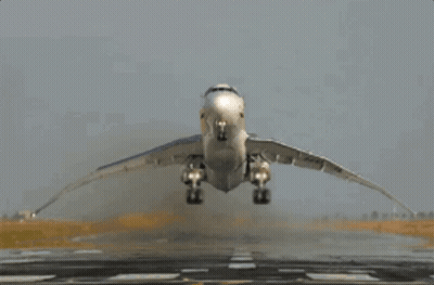 A Plane Is Taking Off From A Runway With Its Wings Spread GIF