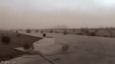 A Plane Is Taking Off From An Airport Runway During A Sandstorm . GIF