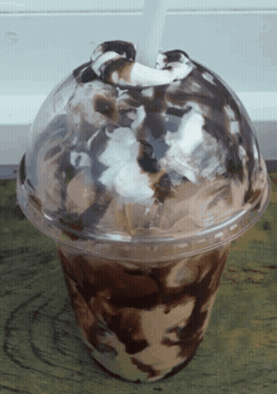 A Plastic Cup Of Ice Cream With Chocolate Sauce And Whipped Cream GIF