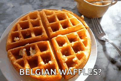 A Plate Of Belgian Waffles With A Fork On A Table GIF