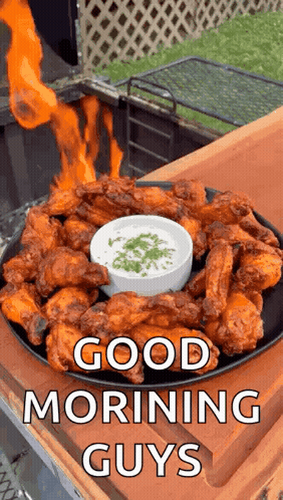 A Plate Of Chicken Wings With A Bowl Of Dipping Sauce And A Fire Coming Out Of It . GIF