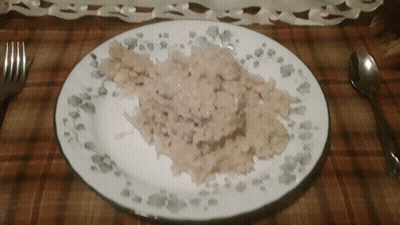A Plate Of Food With A Spoon And Fork On A Table GIF