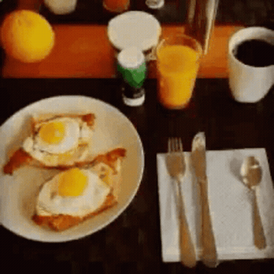 A Plate Of Food With Eggs On Toast On A Table GIF