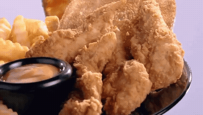 A Plate Of Fried Chicken And French Fries With A Small Bowl Of Dipping Sauce GIF
