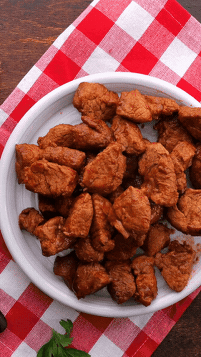 A Plate Of Meat On A Checkered Tablecloth GIF