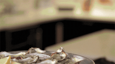 A Plate Of Oysters Sits On A Table GIF