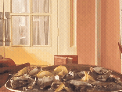 A Plate Of Oysters Sits On A Table In Front Of A Pink Wall GIF