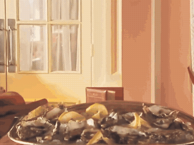 A Plate Of Oysters Sits On A Table In Front Of A Pink Wall GIF