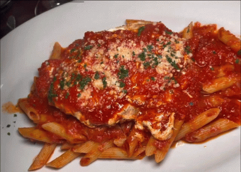 A Plate Of Pasta With Tomato Sauce And Cheese GIF