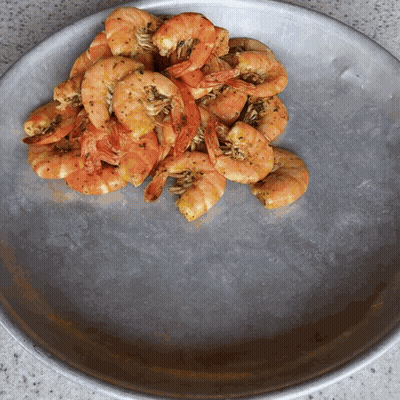 A Plate Of Shrimp Is Sitting On A Counter GIF