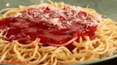 A Plate Of Spaghetti With Sauce And Cheese On It GIF