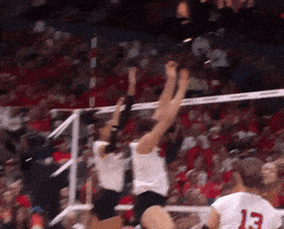 A Player With The Number 13 On Their Jersey Jumps Over A Volleyball Net GIF