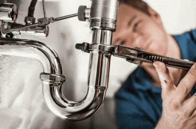 A Plumber Is Working On A Pipe With A Wrench GIF