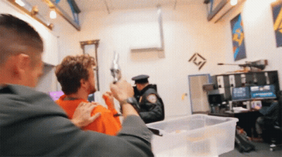 A Police Officer Holds A Gun Over A Man 'S Head GIF