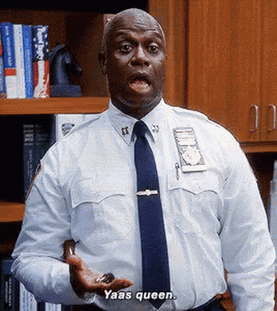 A Police Officer In A White Shirt And Blue Tie Is Holding Something In His Hand And Saying Yaas Queen GIF