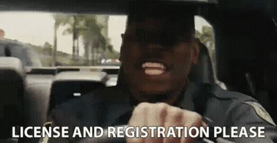 A Police Officer Is Driving A Car And Making A Funny Face . GIF
