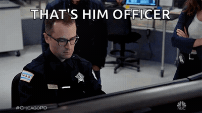 A Police Officer Is Sitting In Front Of A Computer With The Words That 'S Him Officer Above Him GIF