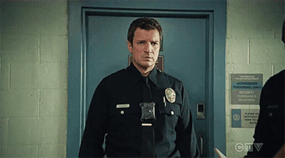 A Police Officer Is Standing In Front Of A Door With A Sign That Says Authorized Personnel Only . GIF