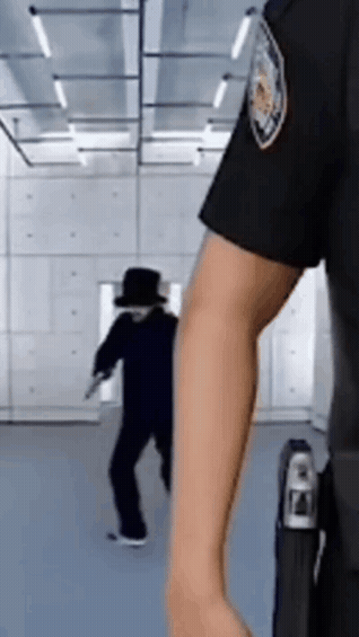 A Police Officer Is Standing In Front Of A Man In A Black Hat . GIF