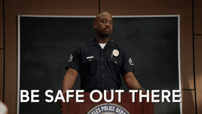 A Police Officer Stands At A Podium With The Words Be Safe Out There GIF