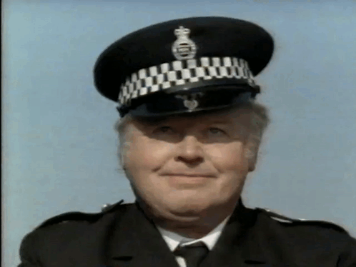A Police Officer Wearing A Black And White Hat With A Crown On It GIF