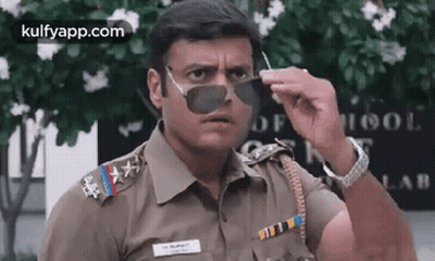A Police Officer Wearing Sunglasses Is Making A Funny Face . GIF