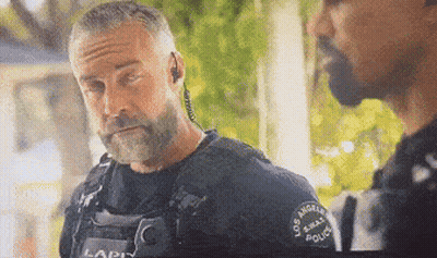 A Police Officer With A Beard Is Talking To Another Police Officer GIF