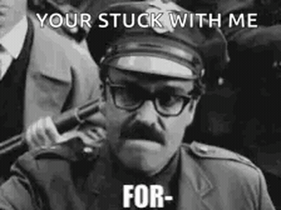 A Police Officer With Glasses And A Mustache Is Holding A Gun In A Black And White Photo . GIF