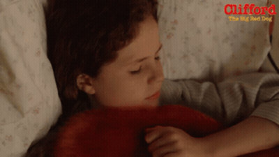 A Poster For Clifford The Big Red Dog Shows A Young Girl Laying In Bed GIF