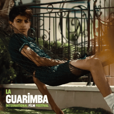 A Poster For La Guarimba International Film Festival With A Man Laying In A Hammock GIF