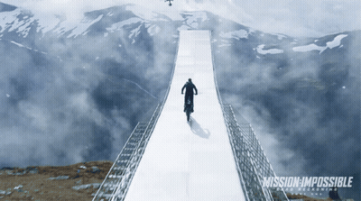 A Poster For Mission Impossible Shows A Man Riding A Motorcycle Over A Bridge GIF