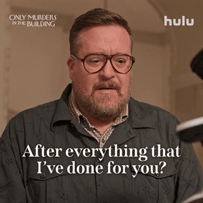 A Poster For Only Murders In The Building Shows A Man With Glasses And A Beard GIF