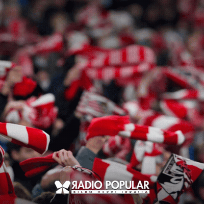 A Poster For Radio Popular Bilbao Herri Irratia Shows A Crowd Of People Wearing Red And White Scarves GIF