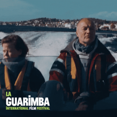 A Poster For The La Guarimba International Film Festival Shows A Man And A Woman In A Boat GIF