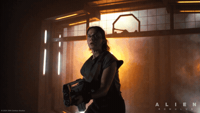 A Poster For The Movie Alien Romulus With A Woman Holding A Gun GIF