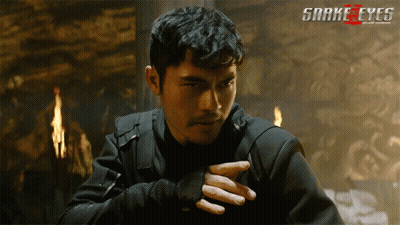 A Poster For The Movie Snake Eyes Shows A Man In A Dark Room GIF