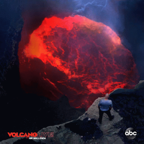 A Poster For Volcano Live Shows A Man Standing On A Cliff GIF