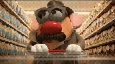 A Potato Head With A Red Nose And Mustache Is Pushing A Shopping Cart In A Store . GIF