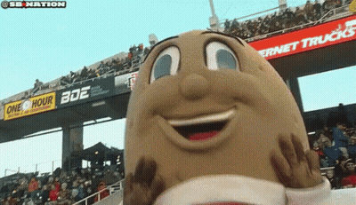 A Potato Mascot Is Smiling In Front Of A Crowd Of People GIF