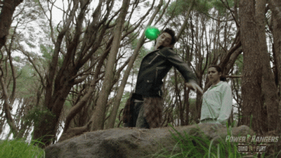 A Power Rangers Ad Shows A Man Holding A Green Ball GIF