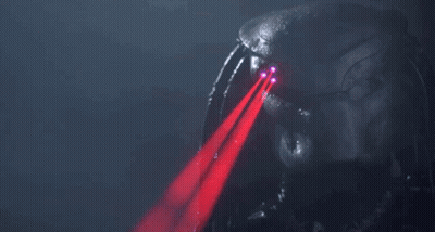 A Predator 'S Eyes Are Glowing Red In The Dark GIF