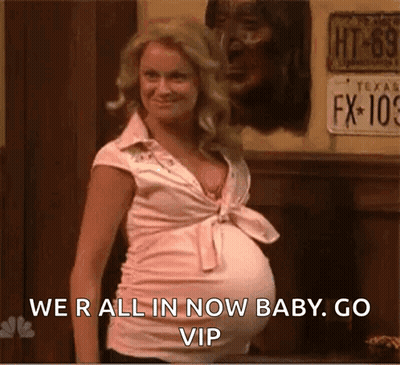 A Pregnant Woman Is Standing In Front Of A Wall With A License Plate That Says Fx-109 GIF
