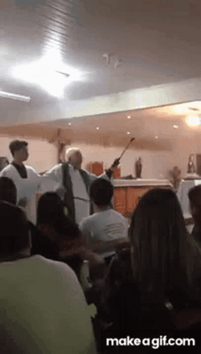 A Priest Is Giving A Sermon In Front Of A Crowd Of People GIF