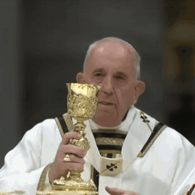 A Priest Is Holding A Golden Chalice In His Hand GIF