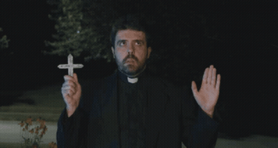A Priest Is Holding A Small Cross In His Hands GIF