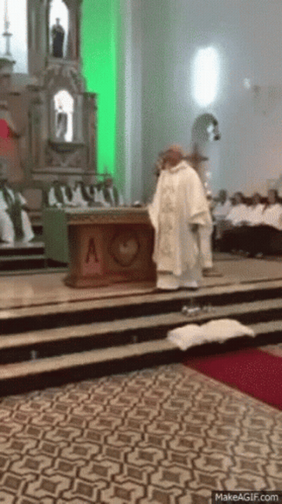A Priest Is Standing In Front Of An Altar With A Heart On It GIF