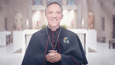A Priest Wearing A Blue Cape With A Cross On His Chest GIF
